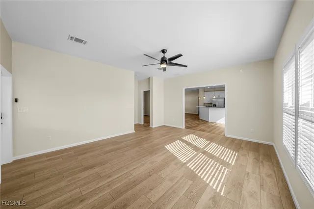 a view of a room with a ceiling fan window and wooden floor