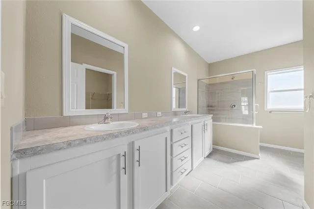 a spacious bathroom with a granite countertop sink mirror and a bathtub