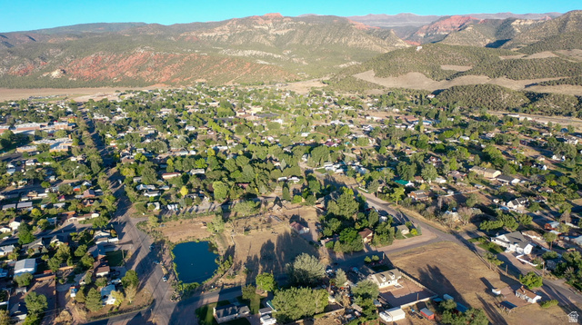426 West Center Street Parowan, UT 84761 - Photo 102 of 107 Expansive aerial capturing a town nestled within a broad valley, featuring numerous residential properties and a central pond