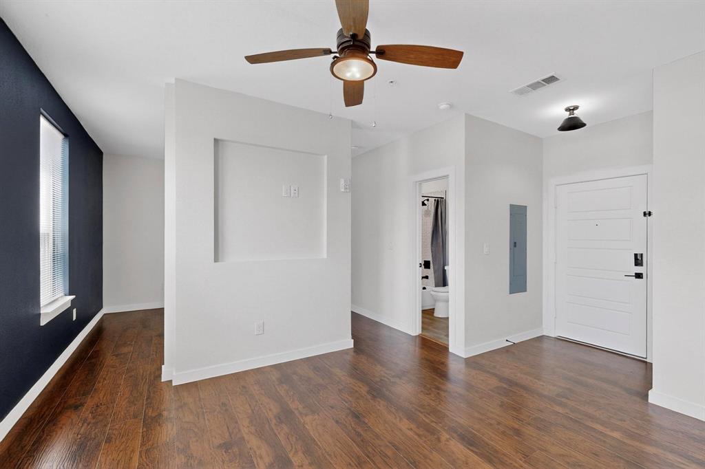 800 South Welch Street, Unit 102 Denton, TX 76201 - Photo 6 of 15 a view of an empty room with wooden floor and a window