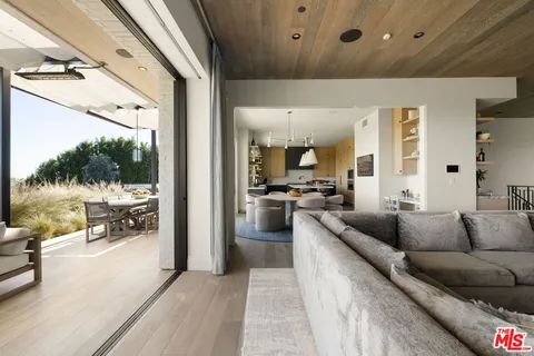 a dining room with furniture a large window and a chandelier