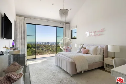 a bedroom with a bed and a flat screen tv