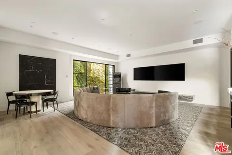 a living room with furniture a flat screen tv and a large window