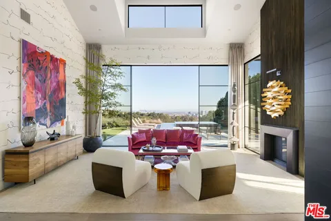 a living room with furniture a fireplace and a floor to ceiling window