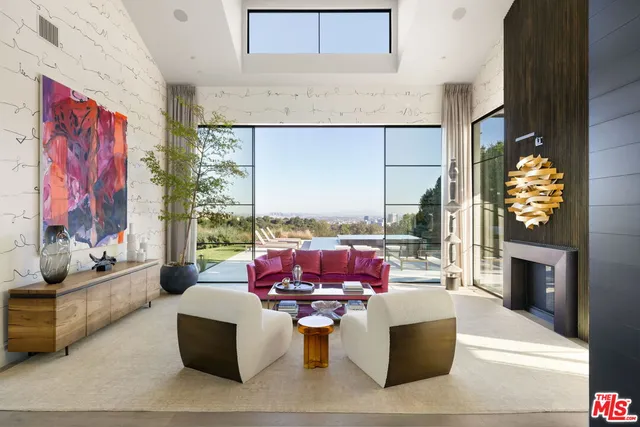 a living room with furniture a fireplace and a floor to ceiling window
