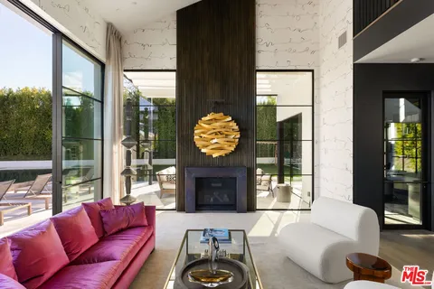a living room with furniture a chandelier and a flat screen tv