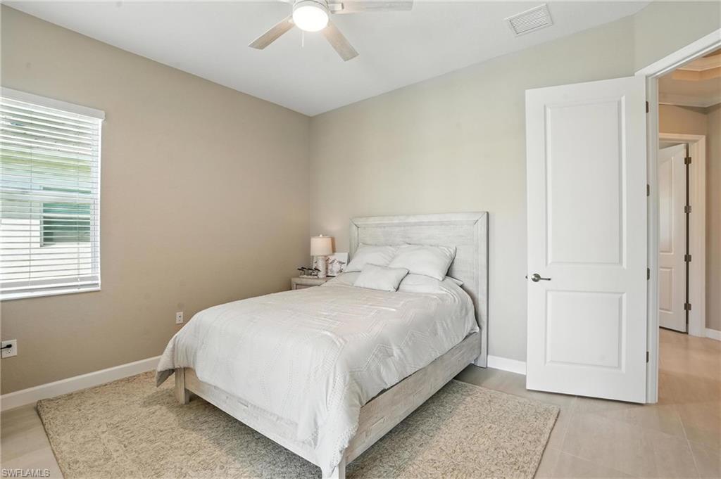 15027 Longs Lane Babcock Ranch, FL 33982 - Photo 33 of 50 a bedroom with a bed and a chandelier