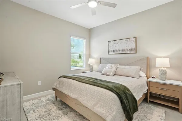 a bedroom with a bed and a flat screen tv in white walls