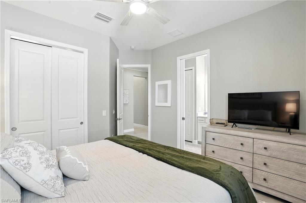 15027 Longs Lane Babcock Ranch, FL 33982 - Photo 37 of 50 a bedroom with a bed and a flat screen tv in white walls