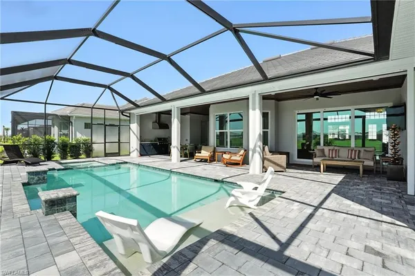 a view of a kitchen with a dining table and chairs under an umbrella