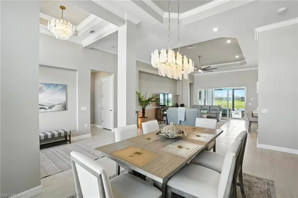 a view of a dining room with furniture a chandelier and wooden floor