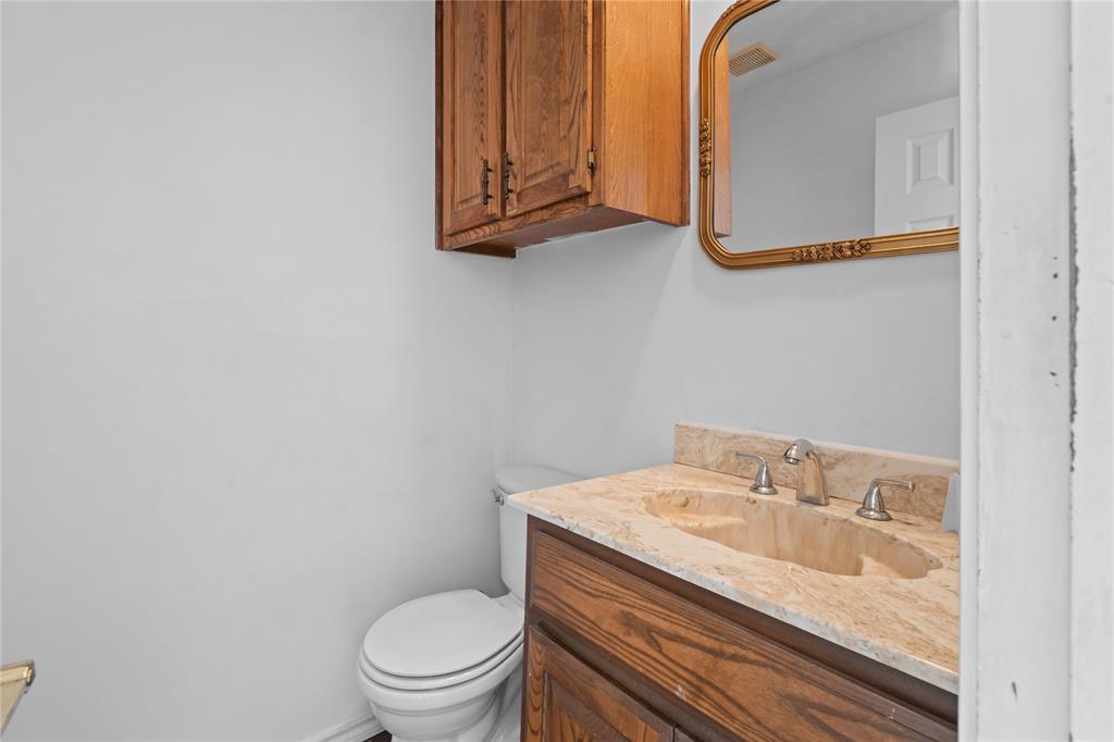 3506 Ruidoso Drive Arlington, TX 76017 - Photo 21 of 37 Bathroom featuring a vanity with a light-toned stone countertop, integrated sink, and an ornate gold-framed mirror