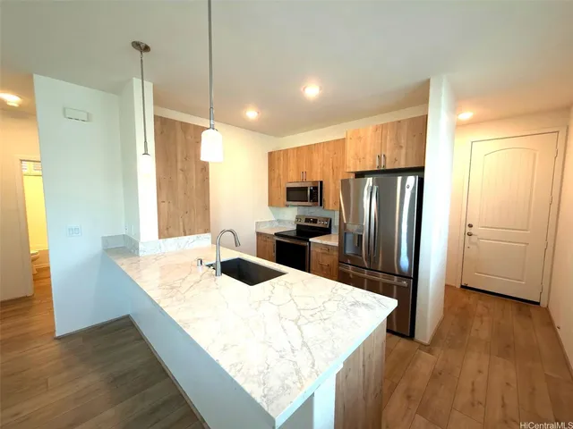 a kitchen with stainless steel appliances granite countertop a refrigerator a sink dishwasher a stove and a refrigerator with wooden floor