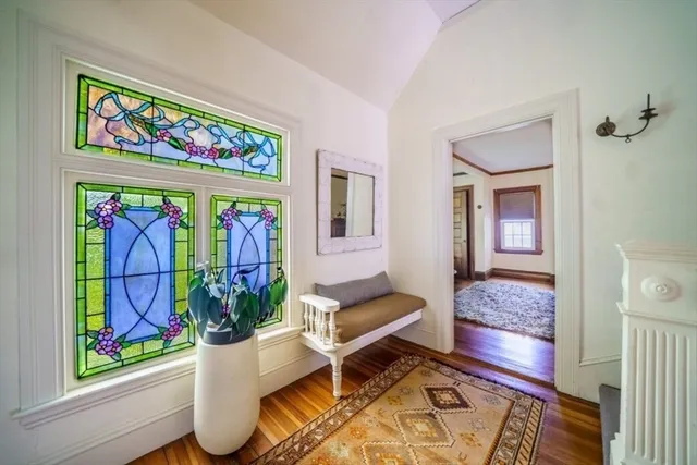 a view of a hallway with wooden floor and furniture
