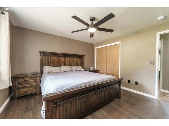 a bedroom with a bed and a ceiling fan