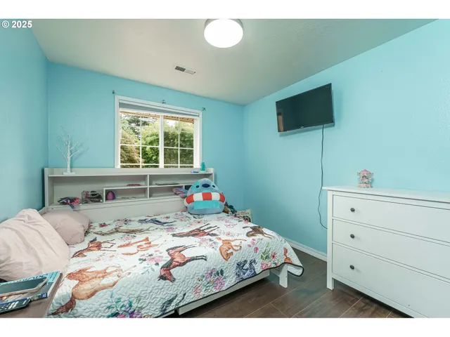 a bedroom with a bed window and a flat screen tv