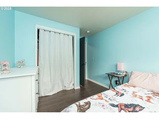 a bed sitting in a bedroom next to a window and a table