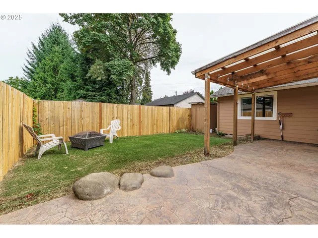 a backyard of a house with table and chairs