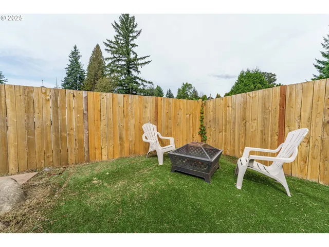 a view of outdoor space with garden and wooden bench