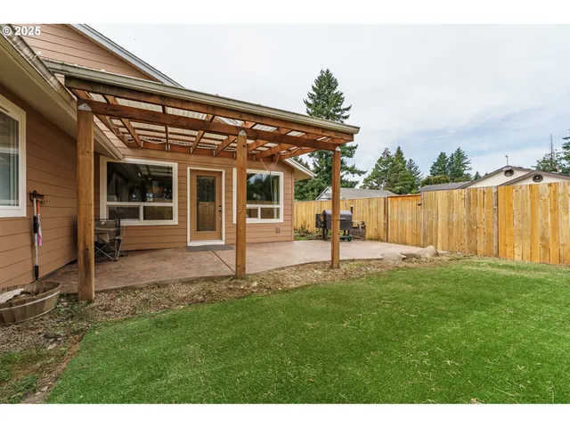 a view of a backyard with table and chairs and wooden fence