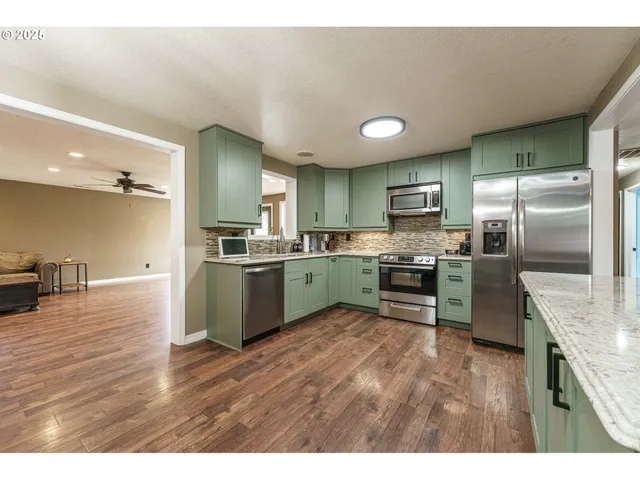 a kitchen with kitchen island a sink stainless steel appliances and cabinets