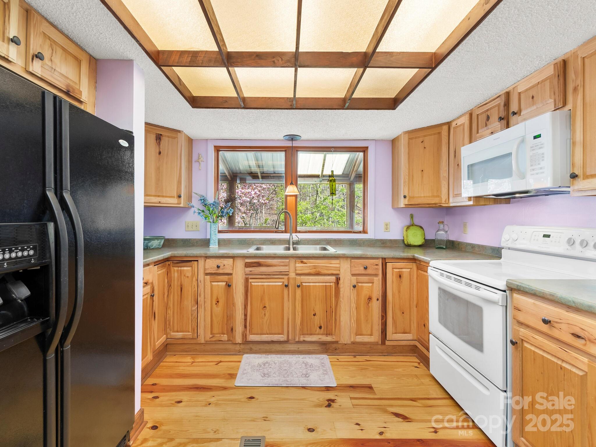70 Fox Run Hot Springs, NC 28743 - Photo 7 of 29 a kitchen with stainless steel appliances granite countertop a refrigerator a sink dishwasher a stove and white countertops with wooden floor