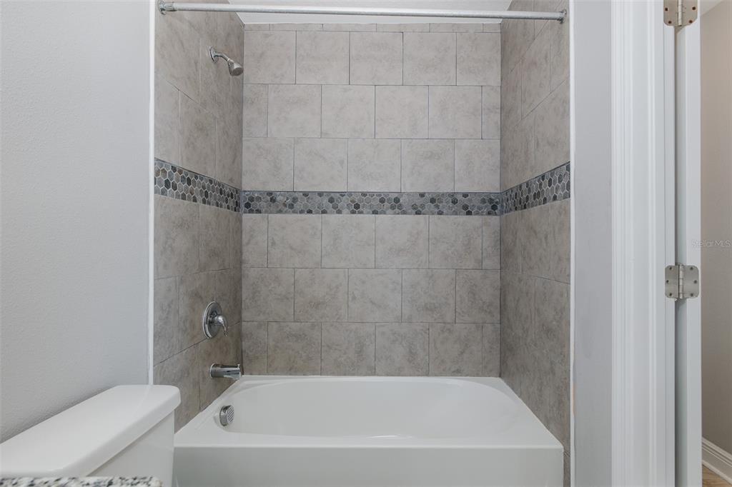 6823 Crossbow Lane New Port Richey, FL 34653 - Photo 16 of 25 a bath tub sitting next to a white toilet and sink