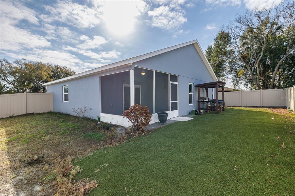 6823 Crossbow Lane New Port Richey, FL 34653 - Photo 23 of 25 a backyard of a house with table and chairs