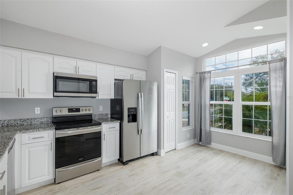 6823 Crossbow Lane New Port Richey, FL 34653 - Photo 7 of 25 a kitchen with stainless steel appliances a stove sink and refrigerator