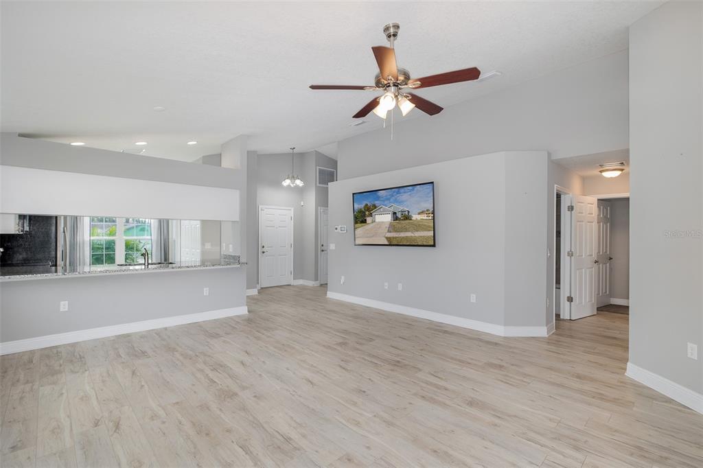 6823 Crossbow Lane New Port Richey, FL 34653 - Photo 9 of 25 a view of an empty room with wooden floor and a ceiling fan