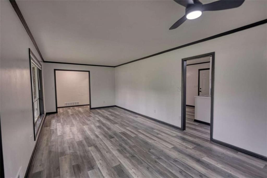 555 Joy Street Jackson, GA 30233 - Photo 13 of 56 an empty room with wooden floor and a ceiling fan