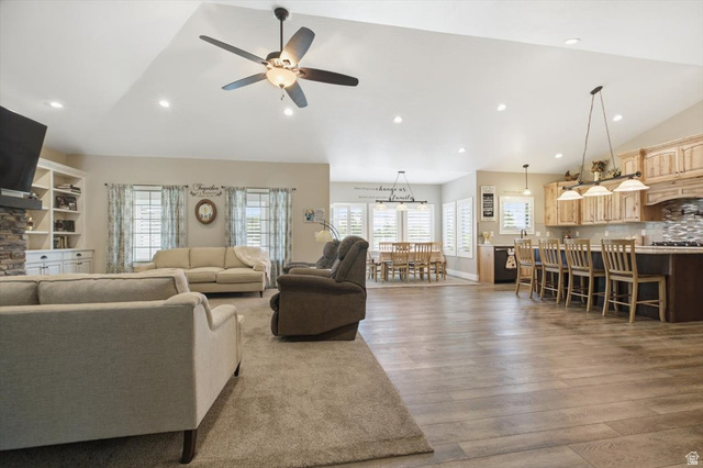 3123 East Riverdale Road Preston, ID 83263 - Photo 6 of 52 Open-concept living space featuring wood-finish flooring, vaulted ceilings with recessed lighting, and a kitchen island with pendant lights