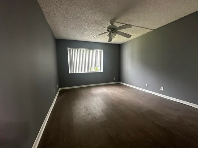 an empty room with windows and fan
