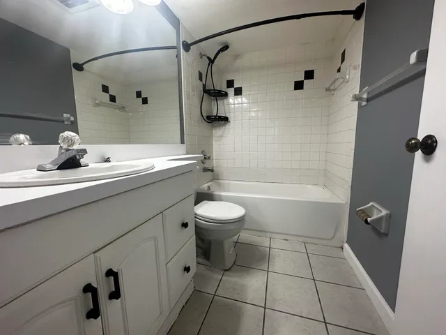 a bathroom with a granite countertop sink a toilet and shower