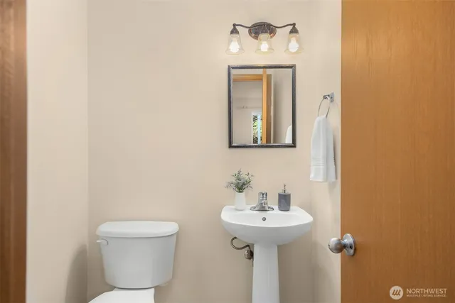 a bathroom with a toilet sink and mirror