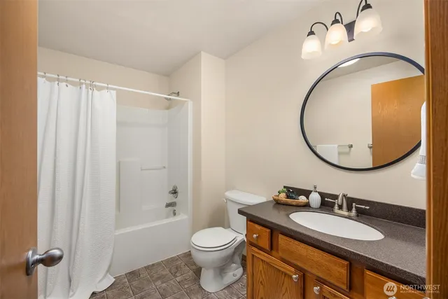 a bathroom with a granite countertop sink toilet and a mirror