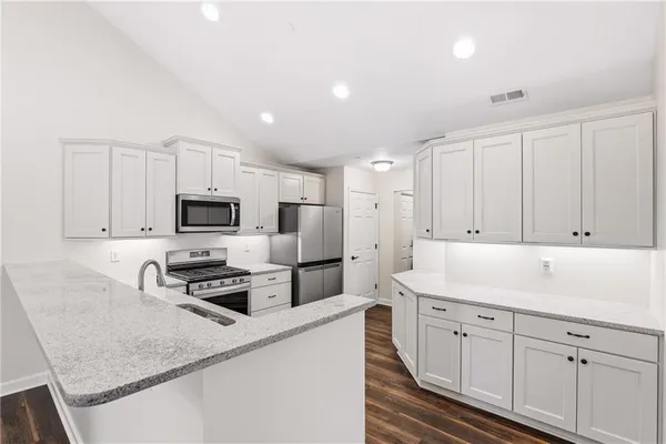 a kitchen with cabinets appliances a sink and a counter top space