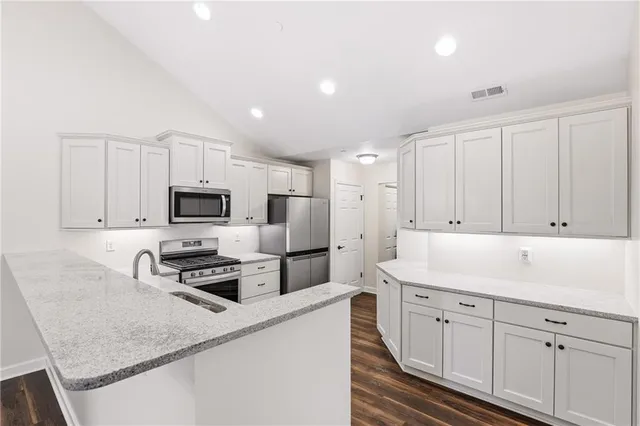 a kitchen with cabinets appliances a sink and a counter top space