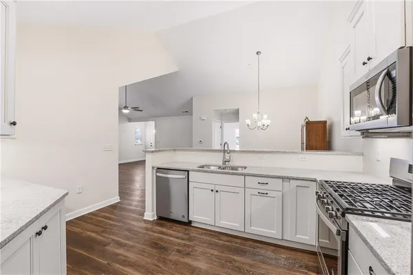 a kitchen with granite countertop a sink stove and cabinets