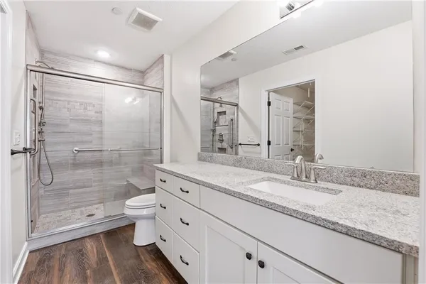 a bathroom with a granite countertop sink toilet and shower