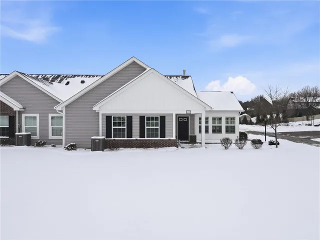 a front view of a house with a yard covered in snow