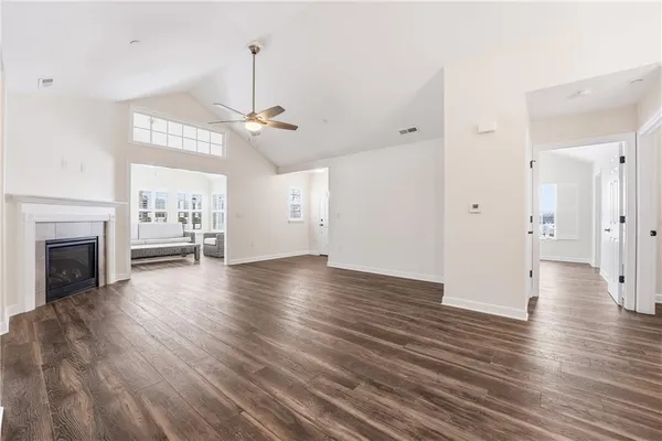 a view of a livingroom with wooden floor fireplace and a window