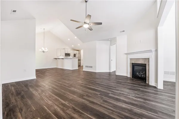 a view of a kitchen with a ceiling fan hardwood floor and a kitchen