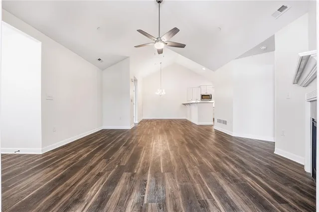 a view of empty room with wooden floor and ceiling fan