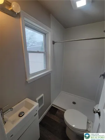 a bathroom with a sink toilet a mirror and shower