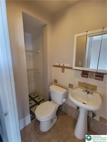 a bathroom with a sink toilet and mirror