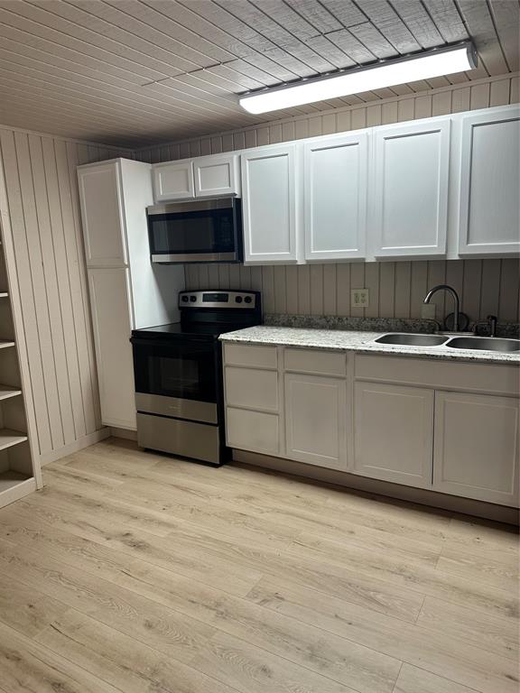 2590 Rock Ridge Road Lucas, TX 75002 - Photo 17 of 25 Kitchen featuring white shaker-style cabinetry, a stainless steel electric range, an over-range microwave, a double basin sink, and wood-finish flooring