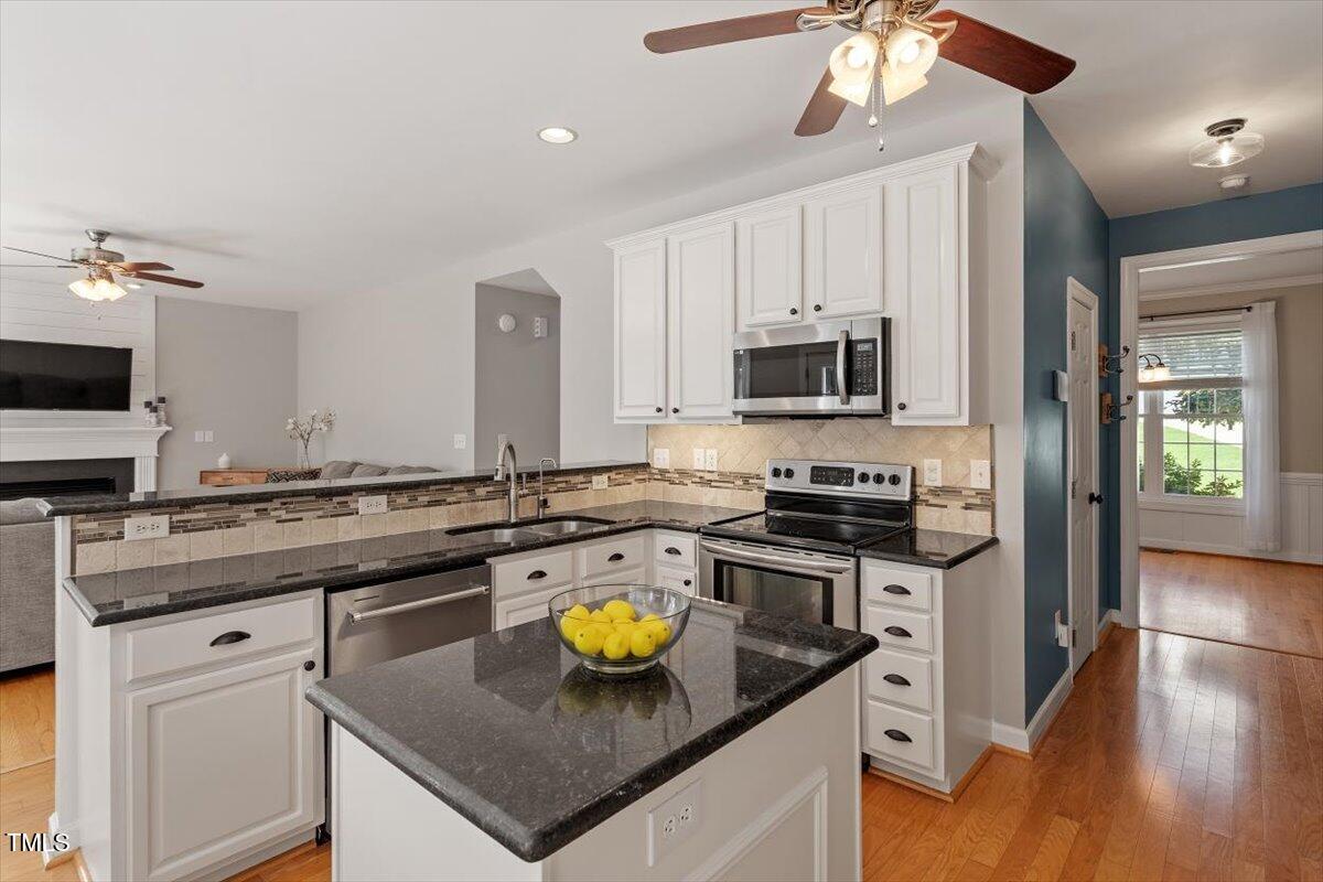 5112 Solemn Grove Road Garner, NC 27529 - Photo 19 of 56 a kitchen with a stove a sink and a refrigerator
