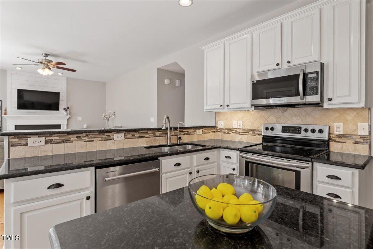5112 Solemn Grove Road Garner, NC 27529 - Photo 21 of 56 a kitchen with stainless steel appliances granite countertop a stove a sink and a microwave
