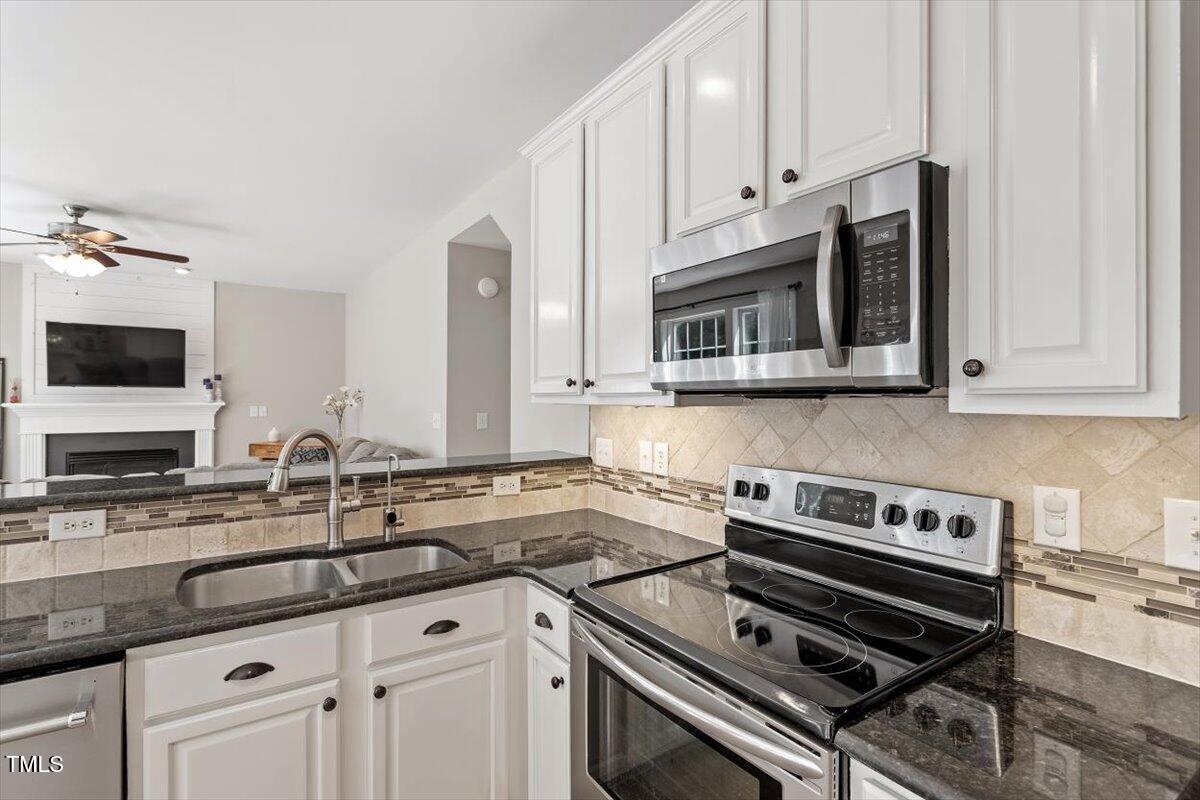 5112 Solemn Grove Road Garner, NC 27529 - Photo 23 of 56 a kitchen with stainless steel appliances a stove a sink a stove and cabinets
